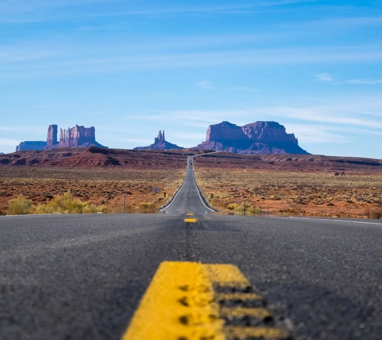 Two-lane highway stretching toward distant mountains